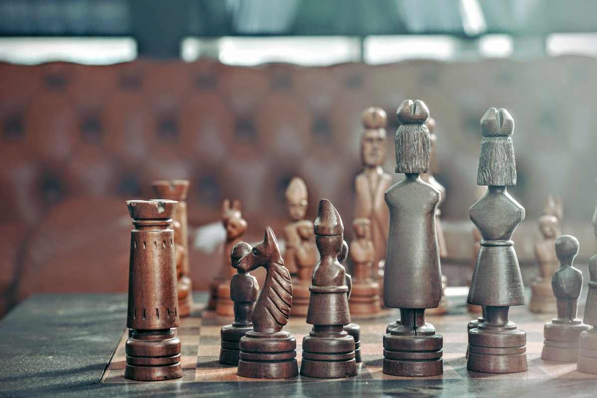 Ξύλινα σκαλιστά πιόνια σκακιού πάνω σε σκακιέρα